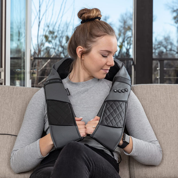 Person using RESTECK massager on neck and shoulders at home.