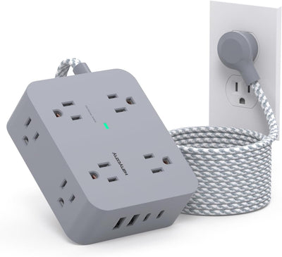 Gray surge protector power strip with multiple outlets, USB ports, and a braided extension cord plugged into a wall.